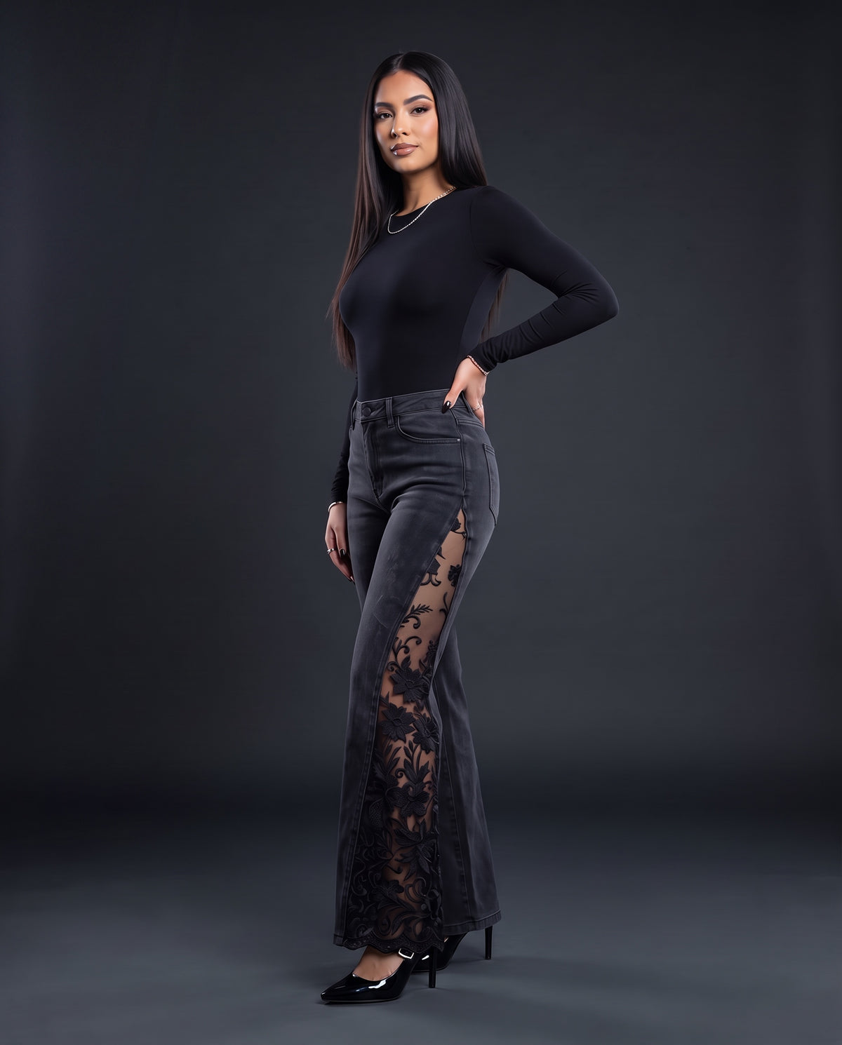 Model wearing black flare jeans with sheer floral lace panels down the outer leg